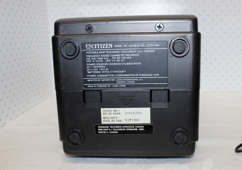 May include: Black and white portable television with the brand name Citizen and model number JCTR 146G. The television has a serial number 00400261 and a manufacturing date of May 1990. The television is made in China.