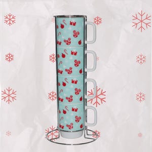 May include: Four stackable mugs with a light blue background and a festive pattern of red candy canes, gift boxes, and Mickey Mouse heads. The mugs are held in a silver metal stand. The mugs are white on the inside and have white handles.
