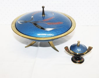 May include: A blue decorative dish with a lid and a smaller matching piece. The dish has a gold rim and three gold legs. The lid features a design with the word "ISRAEL".