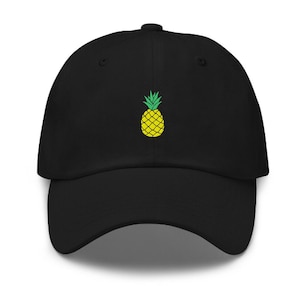 Op de afbeelding: Een zwarte baseballpet met een geborduurde gele ananas op de voorkant.