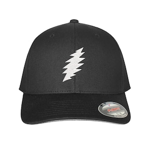 May include: Black baseball cap featuring a white lightning bolt design on the front. The cap has a curved brim and a Flexfit label on the side. A stylish accessory for casual wear.