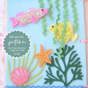 May include: A felt craft project featuring an underwater scene with a pink fish, yellow fish, starfish, and seaweed on a light blue background. The text "PDF and SVG pattern" is visible. The project is bound with pink ribbon and a scalloped edge.