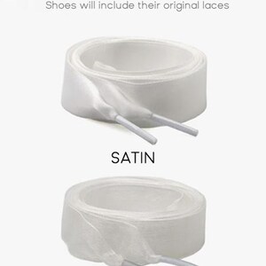 K&ouml;nnte beinhalten: Zwei Paar wei&szlig;e Schn&uuml;rsenkel mit der Aufschrift Free LACES OPTIONS. Das obere Paar ist aus glattem Satin, das untere aus transparentem T&uuml;ll. Der Text lautet: Shoes will include their original laces. Beide Paare sind rund aufgerollt mit Kunststoffenden.