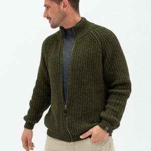 May include: A dark green knitted zip-up cardigan with a high collar and a ribbed texture.