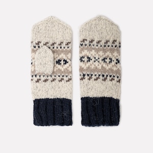 May include: A pair of knitted mittens in a neutral color palette. The mittens feature a fair isle pattern in brown and navy blue, with a navy blue cuff. The mittens are designed for warmth and style.