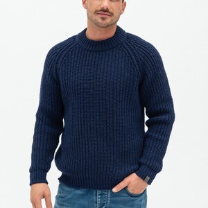 May include: A navy blue knitted sweater with a round neckline and long sleeves. The sweater has a ribbed texture.