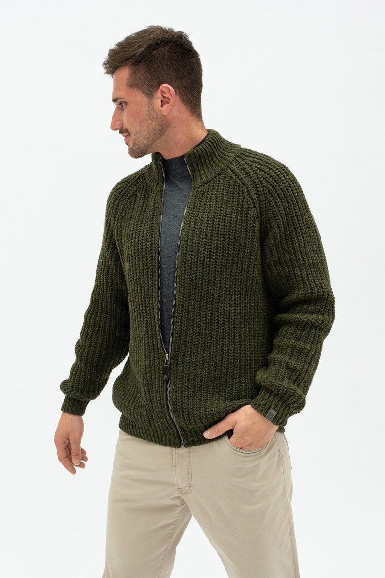May include: A dark green knitted zip-up cardigan with a high collar and a ribbed texture.