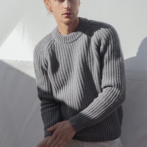 May include: A gray ribbed knit sweater with a crew neck.