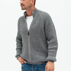 May include: A gray knitted zip-up cardigan with a high collar and ribbed texture.