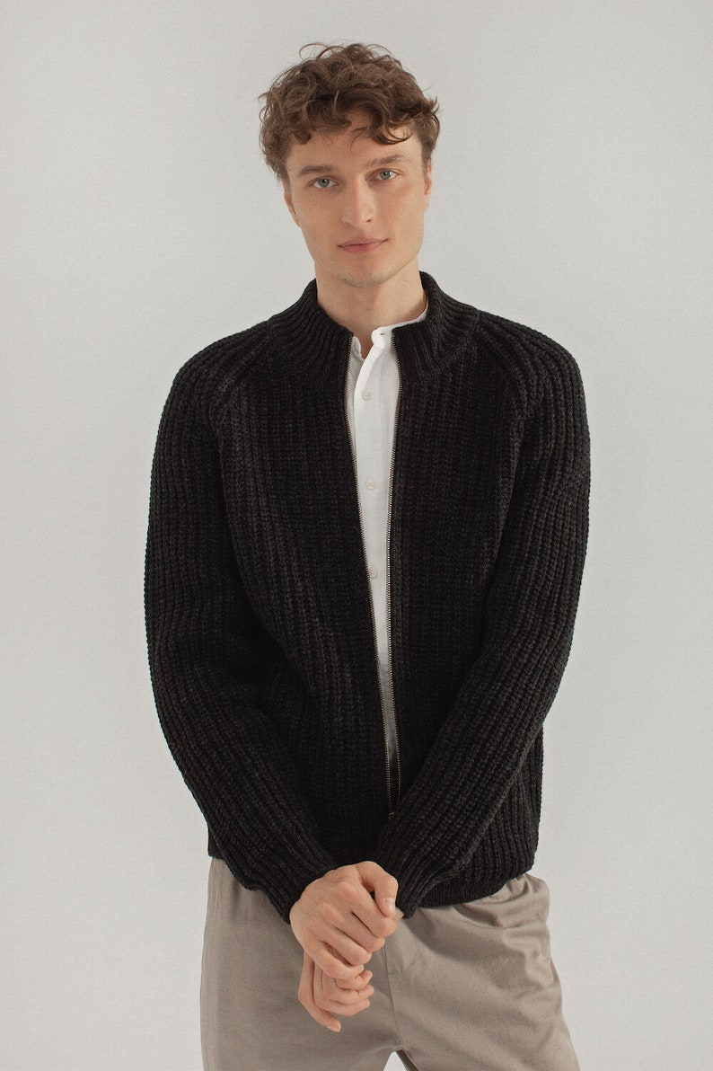 May include: A black knitted zip-up cardigan with a stand-up collar.