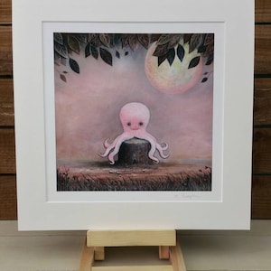 May include: A pink octopus sits on a tree stump in a whimsical forest scene. The octopus has a large, round head with big eyes and a small mouth. The background is a soft pink and purple with a large, full moon and leafy branches.