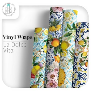 May include: A selection of vinyl wrap rolls with vibrant floral and fruit patterns, including lemons, oranges, and flowers. The wraps display the text "Vinyl Wraps La Dolce Vita". The colour palette includes blue, yellow, and pink hues.
