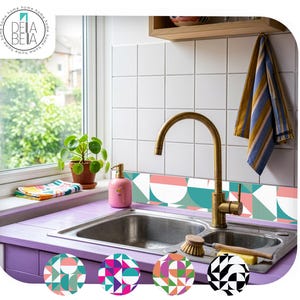 May include: A kitchen sink area featuring a brass faucet, a pink soap dispenser, and a blue and yellow striped towel. The backsplash is decorated with a geometric pattern of teal, pink, and white semicircles and triangles on square tiles.