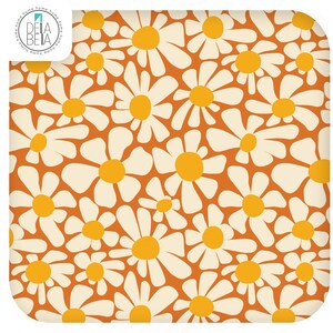 May include: A square fabric swatch featuring a repeating pattern of white daisy flowers with bright yellow centres against a solid burnt orange background. The top left corner displays a circular logo with the text DELA BETA.