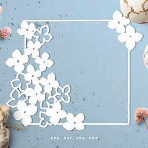 May include: White floral design with a square frame on a light blue background. The design is made up of multiple flower shapes and is perfect for a wedding or other special occasion.