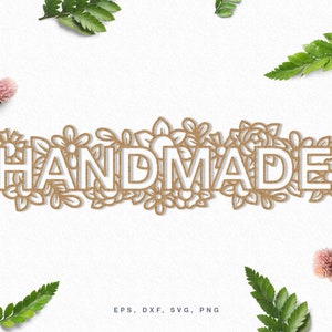 May include: A white "HANDMADE" text design with a floral border. The text is outlined in brown and the flowers are a light brown color.