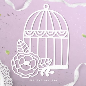 Op de afbeelding: Witte papieren uitsnijding van een vogelkooi met een bloem en bladeren. Het ontwerp is op een lichtpaarse achtergrond. De tekst "EPS, DXF, SVG, PNG" staat onderaan de afbeelding.