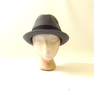 May include: A gray fedora hat with a black band around the crown. The hat is on a mannequin head.