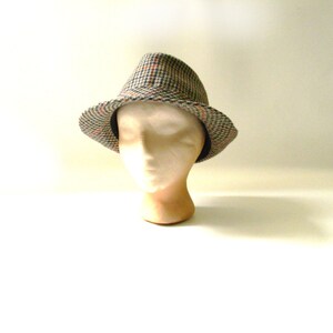 May include: A brown, black, and white plaid fedora hat.