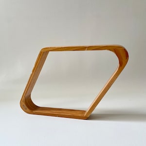 May include: A wooden pool rack with a diamond shape. The rack is made of light brown wood and has a slightly distressed look.