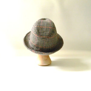 May include: A brown and gray plaid fedora hat with a red and white check pattern.