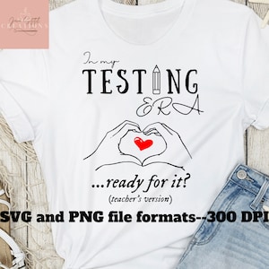 Può includere: Maglietta bianca con testo nero che recita "In my TESTING ERA...ready for it? (teacher's version)". Un cuore rosso con una matita disegnata intorno si trova sopra il testo. Il testo "SVG and PNG file formats--300 DPI" si trova nella parte inferiore della maglietta.