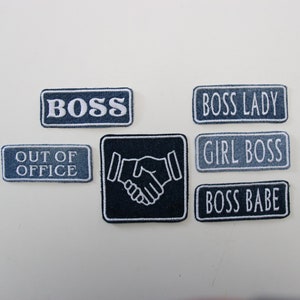 Könnte beinhalten: Ein Set mit sechs Bügelbildern mit verschiedenen Sprüchen zum Thema Chef. Die Patches sind blau und weiß mit weißem Text. Die Sprüche lauten "Boss", "Boss Lady", "Girl Boss", "Boss Babe" und "Out of Office". Ein Patch zeigt eine Handshake-Grafik.