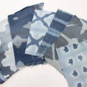 May include: A collection of blue denim fabric squares with different white patterns. The fabric has a distressed look and is perfect for crafting projects.