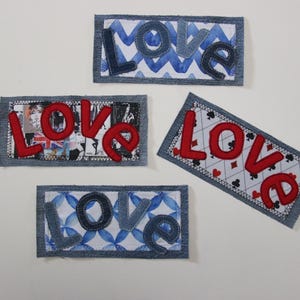 Puede incluir: Cuatro parches rectangulares con la palabra "LOVE" en varios diseños. Las letras son rojas o azul vaquero, con fondos de patrones azules, un collage y un motivo de naipes. Cada parche tiene un borde de mezclilla.