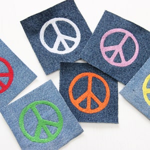 May include: Six denim patches with embroidered peace signs in different colors: white, red, pink, orange, green, and yellow.