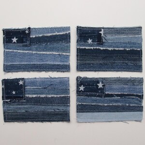 Può includere: Quattro sottobicchieri piccoli a tema bandiera americana realizzati in tessuto denim. Ogni sottobicchiere presenta un design a patchwork di denim blu e bianco con stelle bianche.