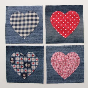 Puede incluir: Cuatro cuadrados de mezclilla con diferentes corazones de tela cosidos en la parte superior. Los corazones son de cuadros rojos y blancos, rojos con lunares blancos, rojos y blancos con un pequeño patrón floral y rojos con un patrón circular blanco y rojo.