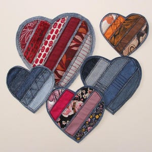 Puede incluir: Cinco posavasos hechos a mano en forma de corazón hechos con recortes de mezclilla y tela. Los posavasos presentan diferentes patrones y colores, incluyendo rojo, azul, rosa y marrón.
