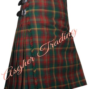 Op de afbeelding: Een groene, rode en gele geruite kilt met zwarte leren riemen en gespen. De kilt heeft een gefranjerde rand en is gemaakt van een geweven stof. Traditioneel Schots kledingstuk.