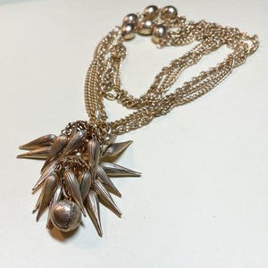 Vintage funky spike tassel pendant, 27 inch long three strand chain necklace, goldtone metal , two tiered tassel jingles, 1960s-70s  NP485