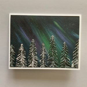 May include: A painting of a snowy forest with a vibrant green, blue, and purple aurora borealis in the night sky.