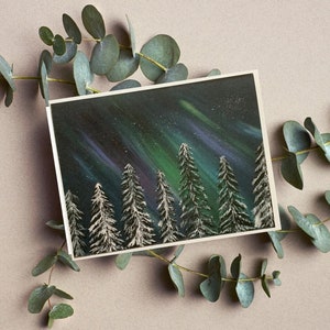 May include: A painting of a snowy forest scene with a green and purple aurora borealis in the night sky.