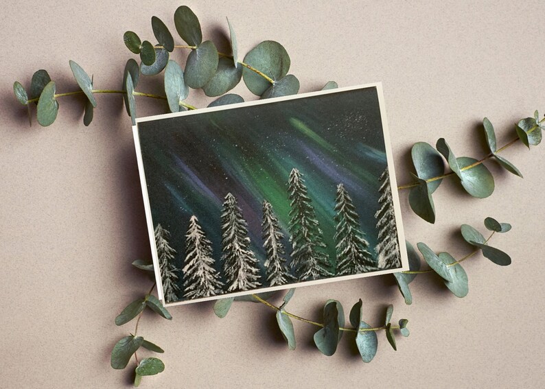 May include: A painting of a snowy forest scene with a green and purple aurora borealis in the night sky.