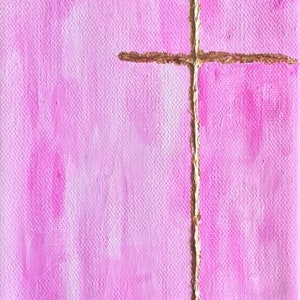 May include: A simple gold cross painted on a pink canvas with a gradient effect.