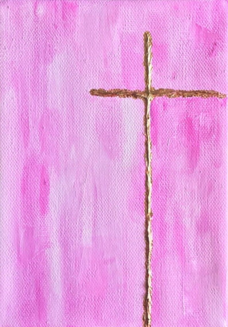 May include: A simple gold cross painted on a pink canvas with a gradient effect.