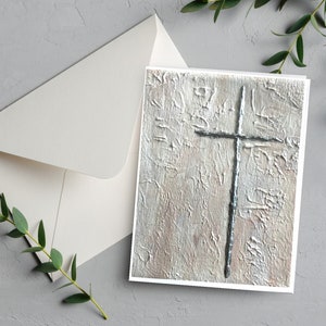 May include: A white card with a silver cross on a textured background. The card is blank and ready for a message.