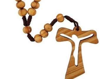 May include: A wooden rosary with brown beads and a brown cord. The crucifix is made of wood and features a cutout of a person on the cross.