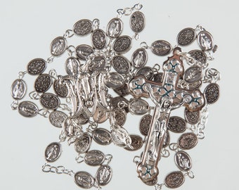 May include: A silver rosary with a crucifix and a medal of the Virgin Mary. The rosary beads are oval-shaped and feature an image of the Virgin Mary.