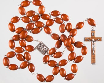 May include: A brown wooden rosary with a silver crucifix and a silver medal featuring a depiction of Jesus. The rosary beads are oval-shaped and strung on a silver chain.