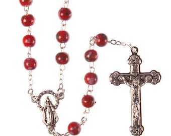 May include: Red rosary beads with a silver crucifix and a silver charm of the Virgin Mary.