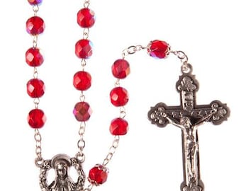 May include: A red crystal rosary with a silver crucifix and a silver charm featuring the Virgin Mary.