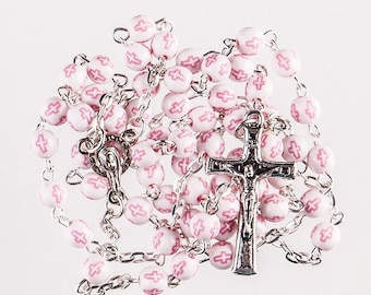 May include: White rosary beads with pink crosses, strung on a silver chain with a silver crucifix.