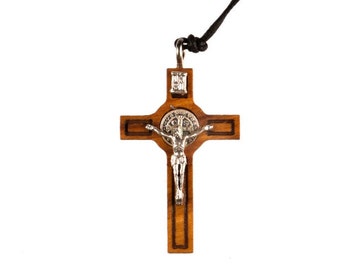 May include: A wooden crucifix pendant with a silver Jesus figure and a silver St. Benedict medal. The pendant is on a black cord.