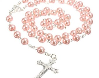 May include: A pink pearl rosary with a silver cross. The rosary is made of small, round pearls and has a silver chain.