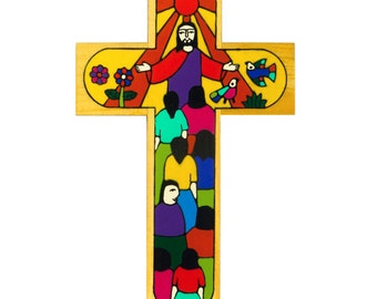 May include: A wooden cross with a colorful painted design depicting Jesus with outstretched arms, a sun, birds, and a group of people. The cross is painted in shades of yellow, red, orange, blue, green, and purple.